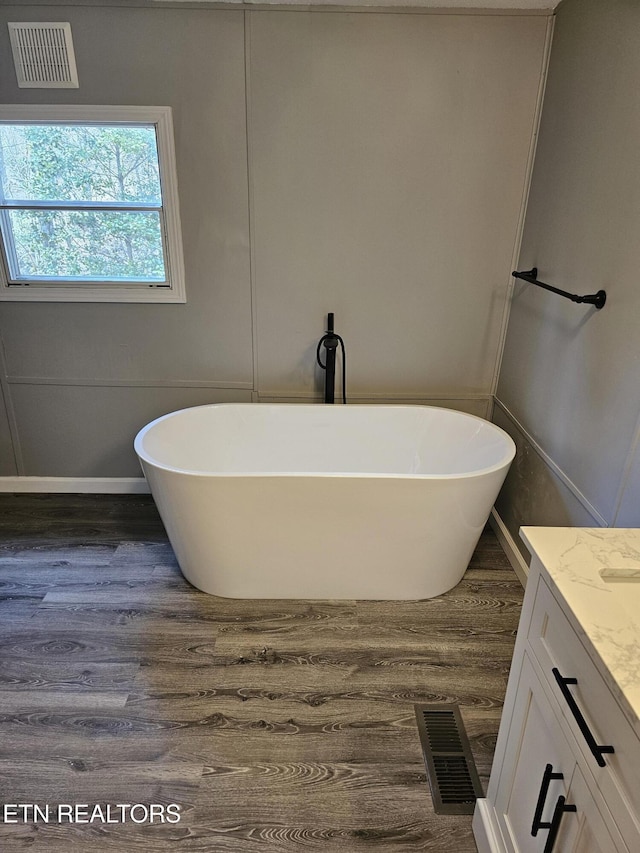 367 Mcjunkin Rd, Tellico Plains, TN 37385 - bathroom with visible vents, a freestanding tub, vanity, and wood finished floors