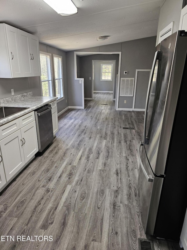 367 Mcjunkin Rd, Tellico Plains, TN 37385 - kitchen featuring light countertops, white cabinets, appliances with stainless steel finishes, and light wood finished floors