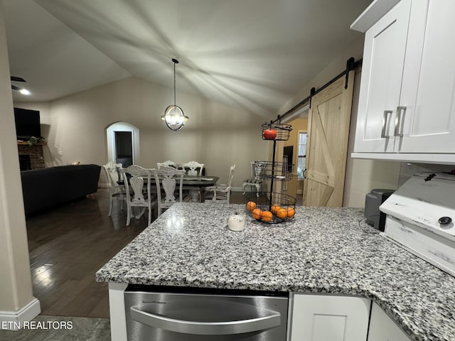 kitchen featuring lofted ceiling, white cabinets, a peninsula, and light stone counters