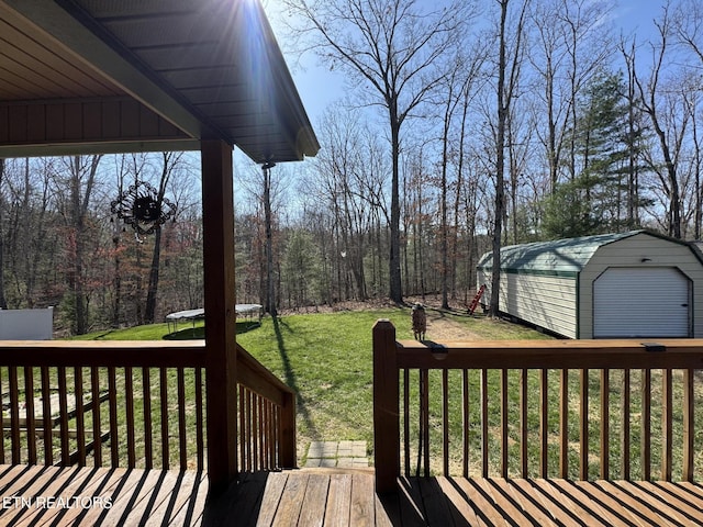deck with a lawn, a shed, an outdoor structure, and a trampoline