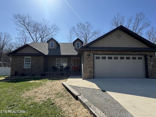 view of front of property featuring concrete driveway, roof with shingles, a front yard, brick siding, and a garage