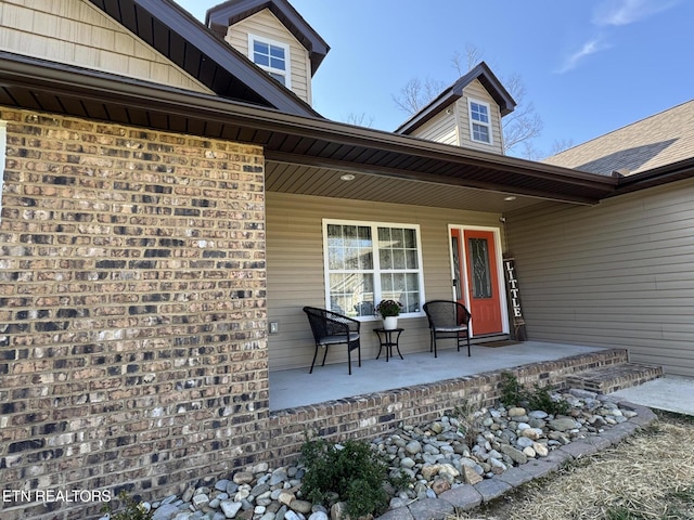 view of exterior entry featuring covered porch