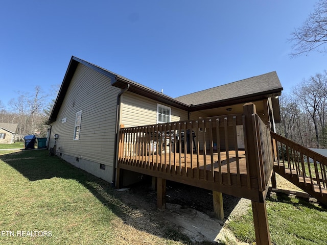 view of side of property featuring crawl space, a deck, and a lawn