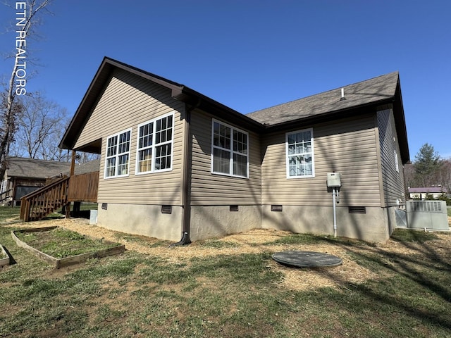 view of property exterior featuring a garden, crawl space, and a lawn