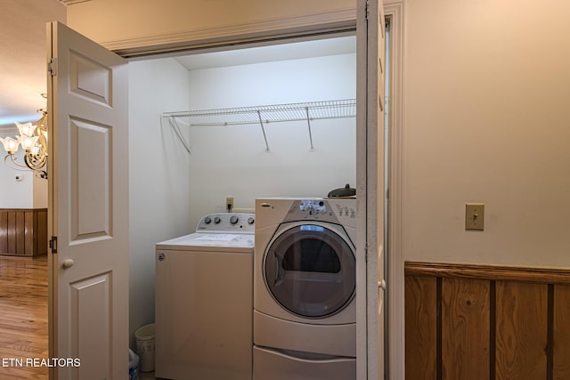 washroom featuring an inviting chandelier, light wood-style flooring, washing machine and dryer, and laundry area