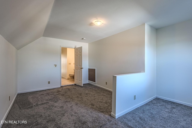 additional living space featuring carpet, baseboards, and lofted ceiling