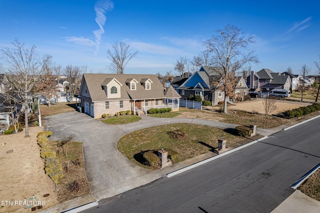 view of front of property with a residential view, a porch, an attached garage, and curved driveway