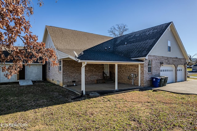 back of property with a lawn, brick siding, crawl space, and a patio area