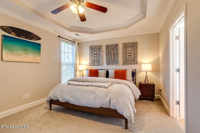 bedroom with ornamental molding, a tray ceiling, baseboards, and light colored carpet
