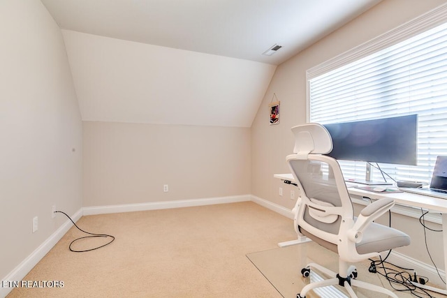 office area featuring baseboards, visible vents, vaulted ceiling, and light colored carpet
