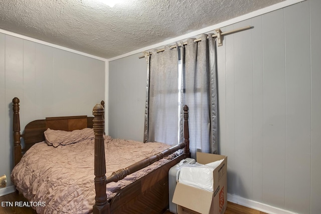 bedroom with wood finished floors and a textured ceiling