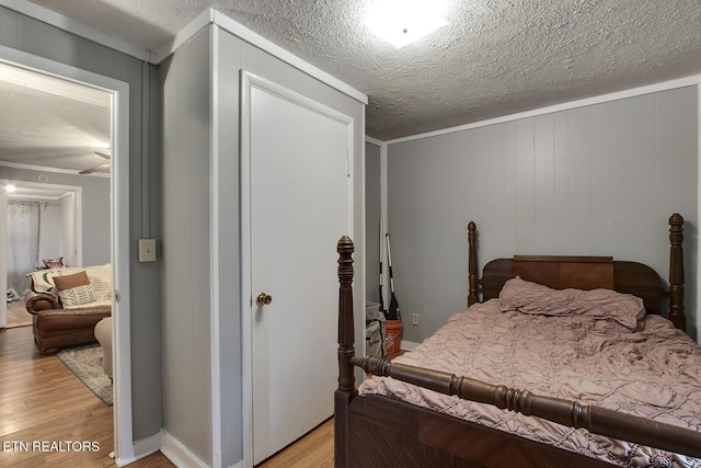 bedroom featuring a textured ceiling and light wood finished floors