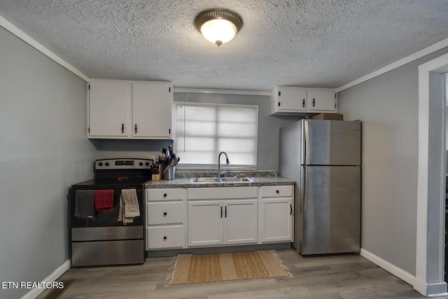 kitchen with a sink, light wood-type flooring, appliances with stainless steel finishes, and white cabinetry