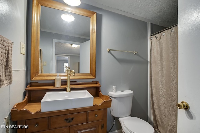 bathroom featuring toilet, vanity, curtained shower, and a textured ceiling