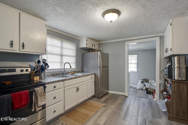 kitchen featuring a sink, light wood-style flooring, stainless steel appliances, baseboards, and white cabinets