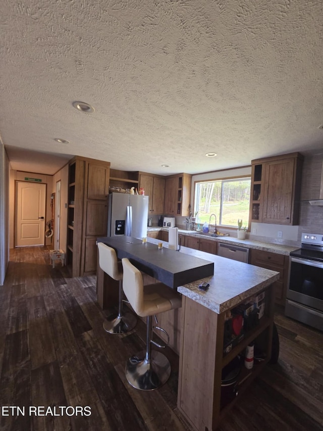 kitchen with dark wood-style flooring, appliances with stainless steel finishes, open shelves, and a kitchen island