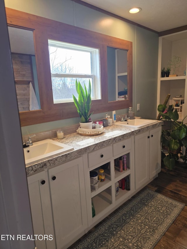 full bath with double vanity, a sink, and recessed lighting