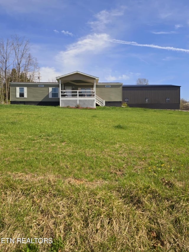 rear view of house with a carport, a deck, and a lawn