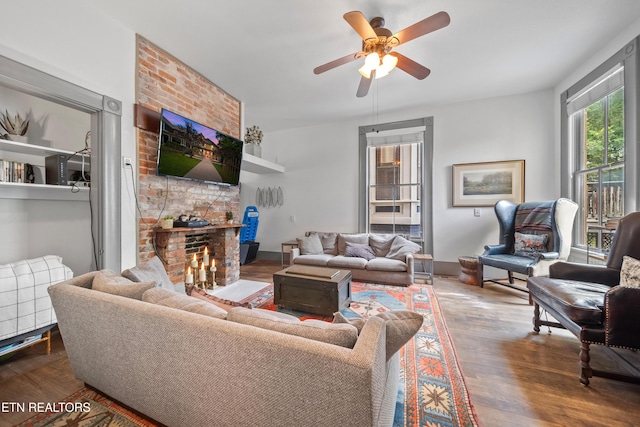 living area with ceiling fan, baseboards, a fireplace, and wood finished floors