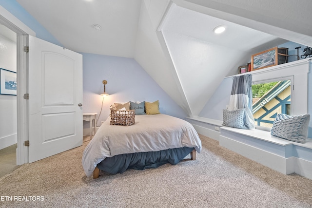 carpeted bedroom with lofted ceiling