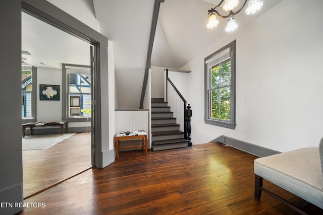 interior space featuring stairs, a healthy amount of sunlight, an inviting chandelier, and wood-type flooring