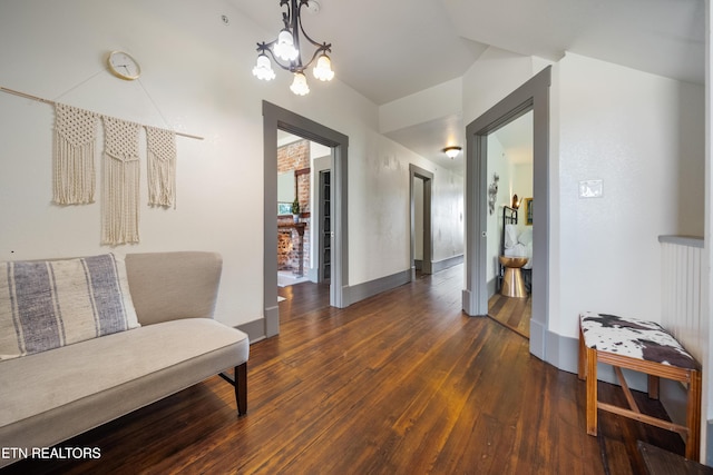 hall with hardwood / wood-style floors, an inviting chandelier, and baseboards