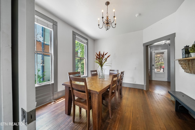 dining area with hardwood / wood-style floors, a notable chandelier, and baseboards