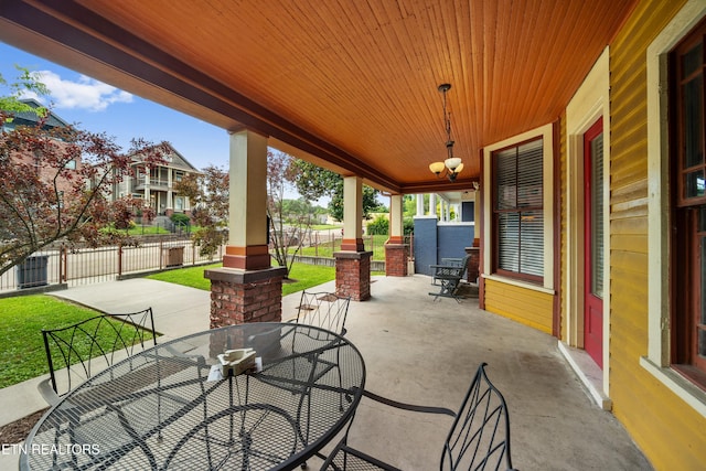 view of patio / terrace with outdoor dining area, fence, and a porch