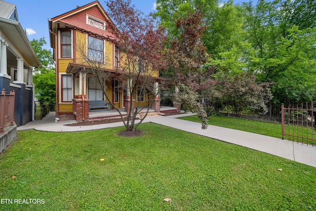 view of front of home featuring a front yard, a porch, and fence