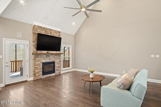 sitting room with a wealth of natural light, high vaulted ceiling, a ceiling fan, and dark wood finished floors