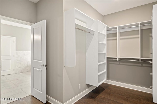 walk in closet with wood finished floors