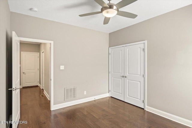 unfurnished bedroom featuring baseboards, visible vents, and wood finished floors