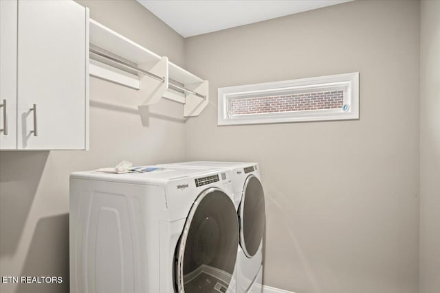 laundry room with separate washer and dryer and cabinet space