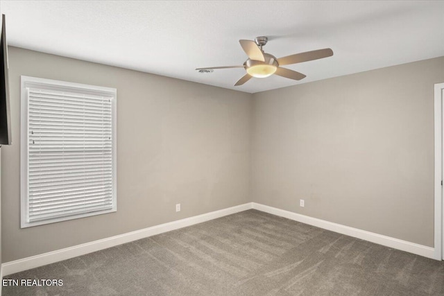 empty room with carpet flooring, baseboards, and ceiling fan