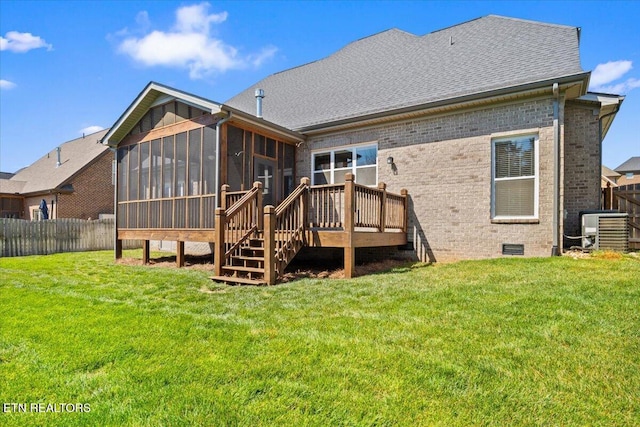 back of property featuring a lawn, a sunroom, brick siding, and fence private yard