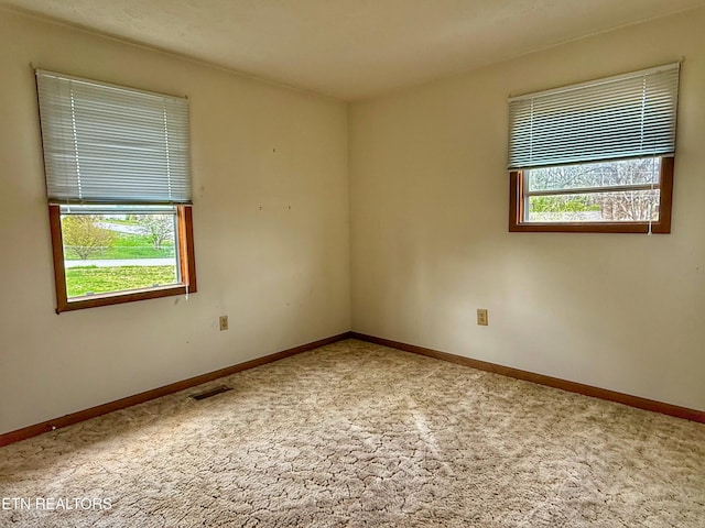 carpeted empty room with baseboards and visible vents