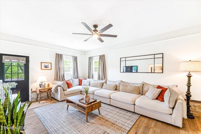 living area with light wood-style floors and a ceiling fan