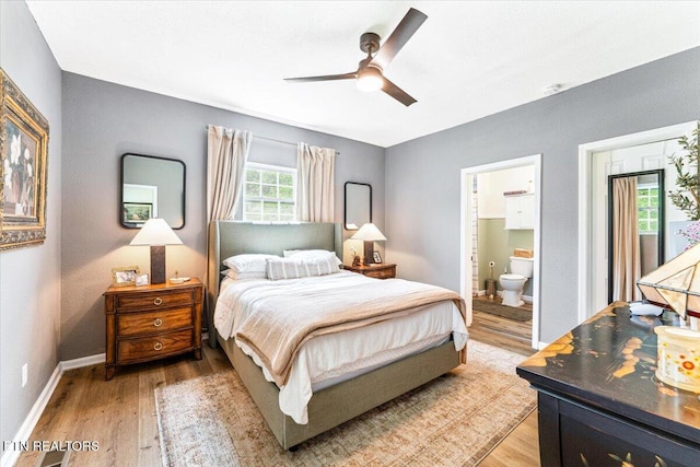bedroom featuring baseboards, ensuite bathroom, a ceiling fan, and light wood finished floors
