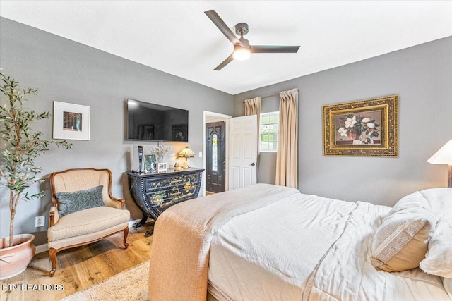 bedroom featuring baseboards, wood finished floors, and ceiling fan