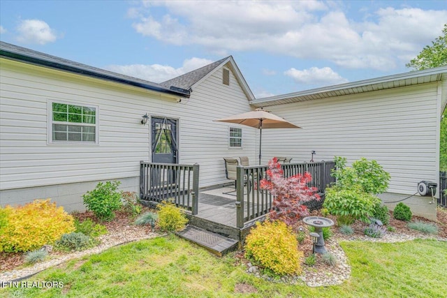 back of house featuring a deck and a yard