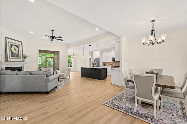 dining room with light wood-type flooring, crown molding, recessed lighting, and ceiling fan with notable chandelier