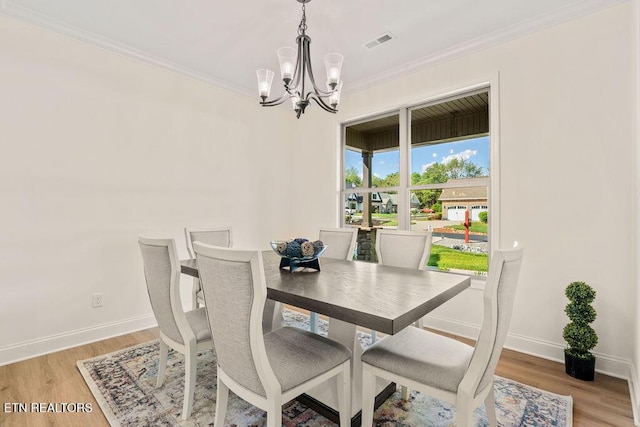 dining space featuring ornamental molding, a notable chandelier, visible vents, and baseboards