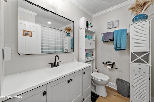 full bathroom with a textured ceiling, toilet, wood finished floors, vanity, and ornamental molding