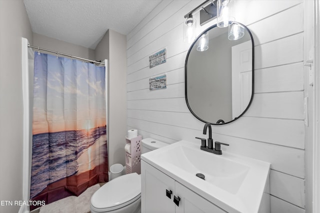 full bath with wood walls, toilet, vanity, a shower with shower curtain, and a textured ceiling