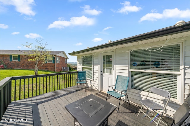 wooden deck with a yard and cooling unit