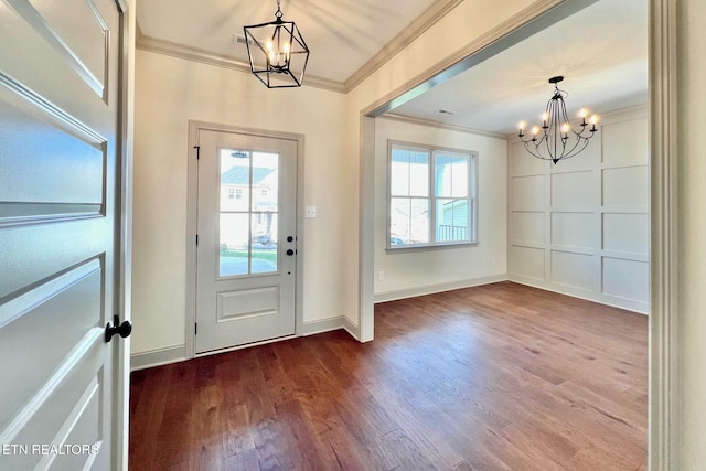 foyer with crown molding, baseboards, a chandelier, and wood finished floors