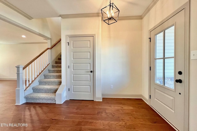 foyer with baseboards, wood finished floors, stairway, and crown molding