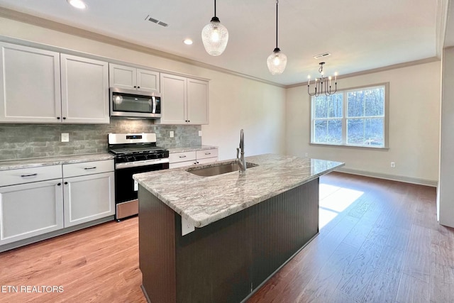 kitchen featuring ornamental molding, stainless steel appliances, backsplash, a sink, and visible vents