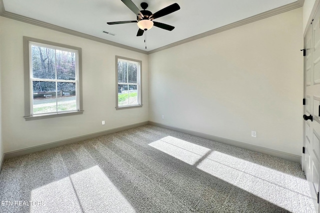 empty room featuring carpet flooring, ornamental molding, baseboards, visible vents, and a ceiling fan