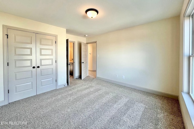 unfurnished bedroom with baseboards, a closet, and carpet